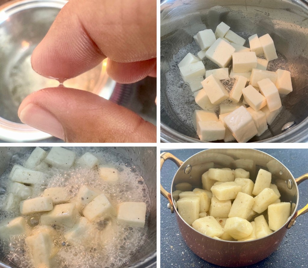 A hand holding a small piece of cheese above a pot of boiling water.